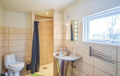 a bathroom with a sink and a toilet and a window at 2 Bedroom Awesome Home In Gedser in Gedser