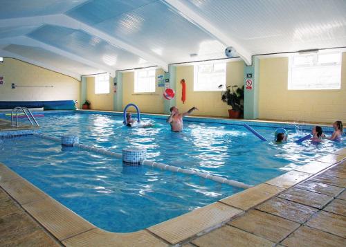 a group of people swimming in a swimming pool at Pencnwc Holiday Park in Llanllwchaiarn