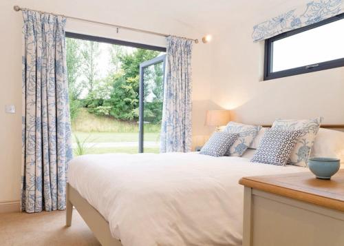 1 dormitorio con cama y ventana grande en Cedar Retreats en Masham