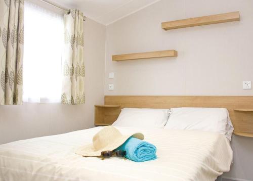 a bedroom with a bed with a hat on it at Stunning Home In Looe W- in Looe