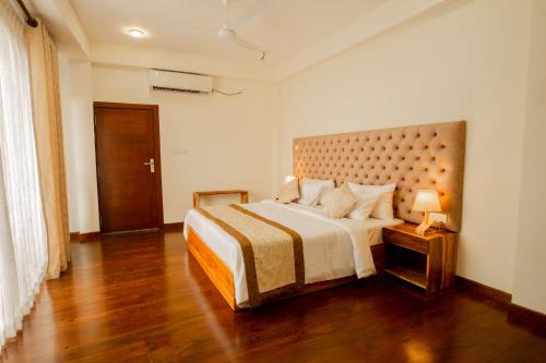 a bedroom with a large bed and a wooden floor at Manthra Leisure in Kandy