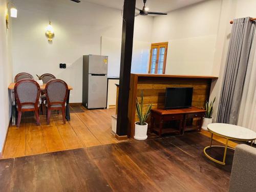 a room with a table and chairs and a television at Roya Khmer House in Siem Reap