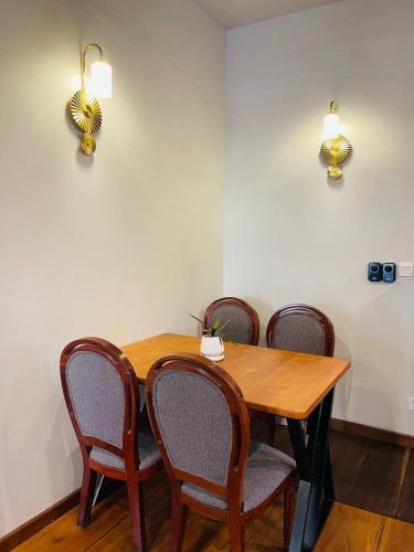a wooden table with chairs and lights on the wall at Roya Khmer House in Siem Reap