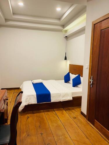 a bedroom with a bed with blue pillows on it at Roya Khmer House in Siem Reap