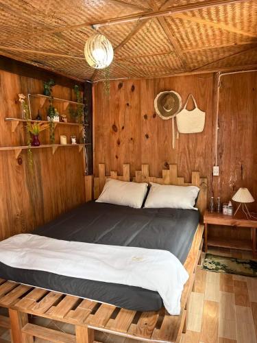 um quarto com uma cama numa parede de madeira em Mộc Home em Cu Lao Thu