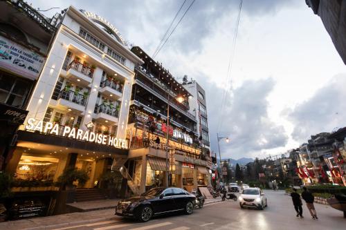 uma movimentada rua da cidade com edifícios e carros na rua em Sapa Paradise Hotel em Sa Pa