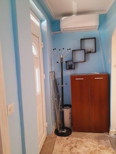 a room with a blue wall with a fan and a door at Apartman Radoman in Cetinje