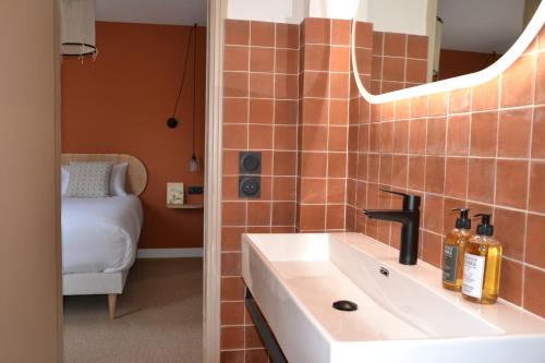 La salle de bains est pourvue d'un lavabo et d'un miroir. dans l'établissement Hôtel La Garrigue & Bar Piscine, à Venasque