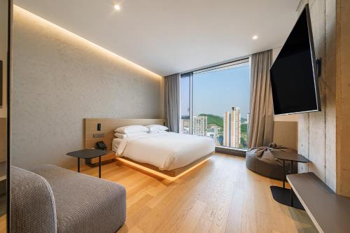 a hotel room with a bed and a large window at Take Hotel Seoul Gwangmyeong in Gwangmyeong