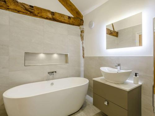 a bathroom with a white tub and a sink at 4 Bed in Skipton 84017 