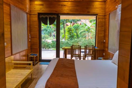 a bedroom with a bed and a table and chairs at Green Mountain Homestay in Ninh Binh