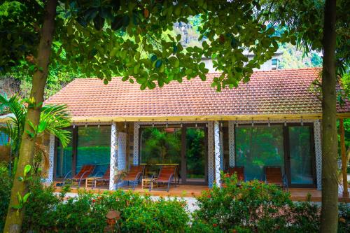 Cette maison dispose d'une terrasse avec des chaises et des tables. dans l'établissement Green Mountain Homestay, à Ninh Binh