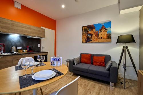 ein Wohnzimmer mit einem Tisch und einem Sofa in der Unterkunft Le Faidherbe style Appart' Hôtel - WIFI gratuit - Parking Gratuit Calme et Lumineux in Nevers