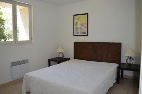 - une chambre avec un lit blanc et 2 tables de nuit dans l'établissement Château du Fenouillet - Logement Porquerolles 72M2, à Hyères