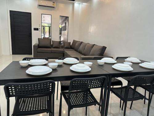 a black table with chairs and plates and a couch at Townes Blackrock Most Unique Home Big Grp Fam Near Downtown SM Dvo DGT Roxas Coastal in Davao City