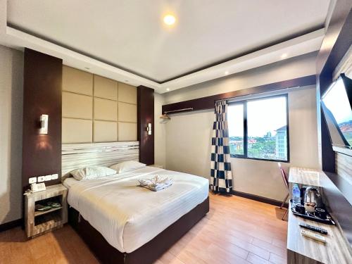 a bedroom with a large bed and a large window at My Home Hotel Pontianak in Pontianak