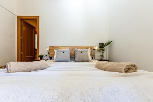 uma grande cama branca com duas almofadas em GROOOVY Dúplex amb Terrassa em Tarragona