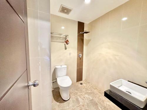 a bathroom with a toilet and a sink at My Home Hotel Pontianak in Pontianak