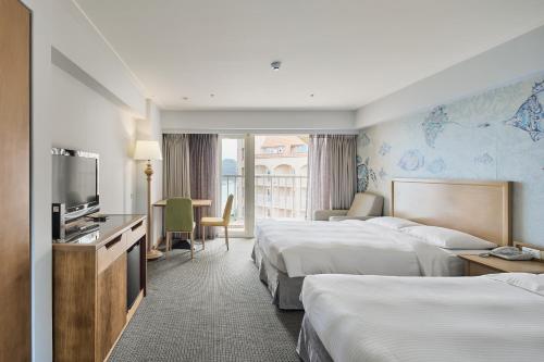 Cette chambre comprend deux lits et une télévision. dans l'établissement Beach Resort Green Bay, à Wanli