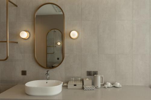 a bathroom with a sink and a mirror at Akara Hotel Pattaya in Pattaya North
