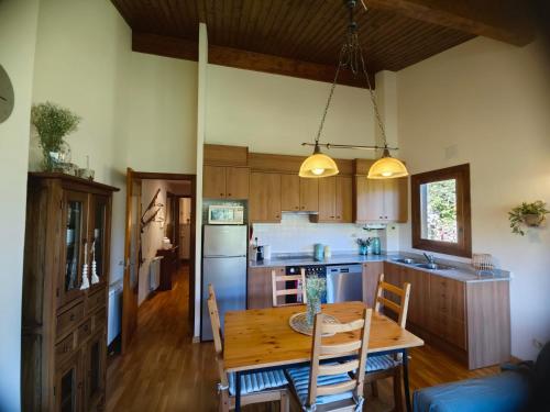 a kitchen with a wooden table and a dining room at Can Geneta in Molló
