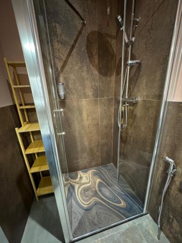 um chuveiro com uma porta de vidro com uma pintura no chão em B&B Parma Centro em Parma
