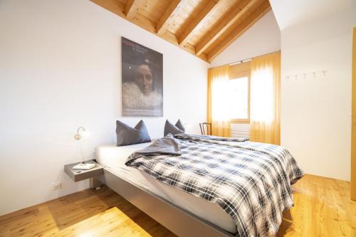 um quarto com uma cama com um cobertor xadrez em Chasa Capricornin em Scuol