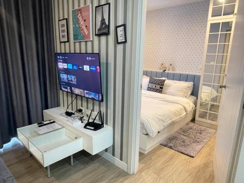 a bedroom with a bed and a tv on a wall at Love on top @ The Blu X bangsaen in Ban Bang Saen (1)