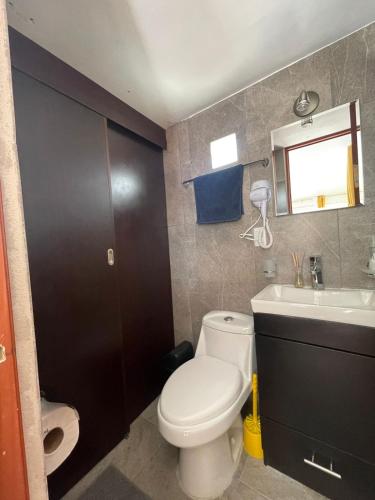 a bathroom with a white toilet and a sink at ¡Intimo, pequeño, confortable, mejor que hotel! in Mexico City