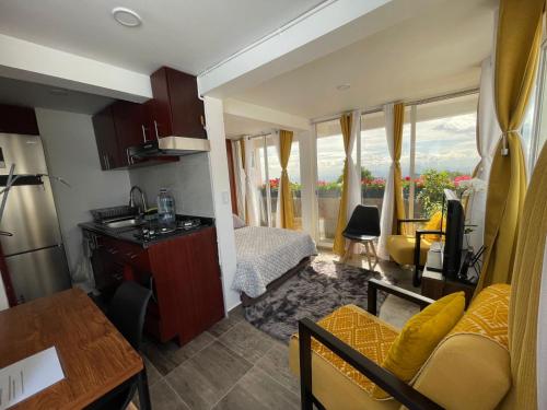 a small room with a bed and a kitchen with a view at ¡Intimo, pequeño, confortable, mejor que hotel! in Mexico City