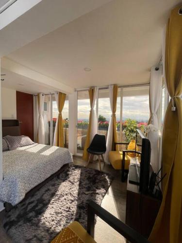 a bedroom with a bed and a large window at ¡Intimo, pequeño, confortable, mejor que hotel! in Mexico City