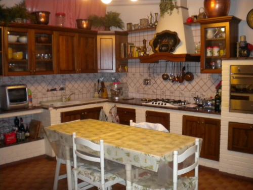 a kitchen with a table with chairs and a counter top at Villa Nanda a 15 minuti da Roma piscina esclusiva , villa nella natura in Formello