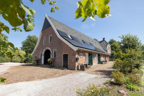 a brick building with a solar roof on it at Hofstede de Rieke Smit in Wilsum