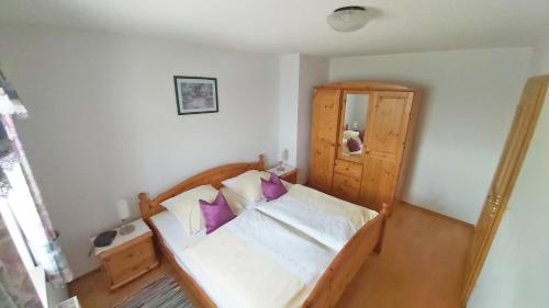 a bedroom with a bed with purple pillows at Ferienhof Obermaier in Bad Birnbach