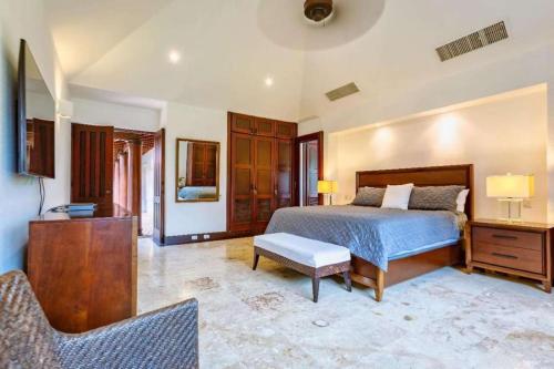 Beautiful and Comfortable Four Bedroom Villa في Cajuiles: غرفة نوم بسرير وطاولة وكراسي