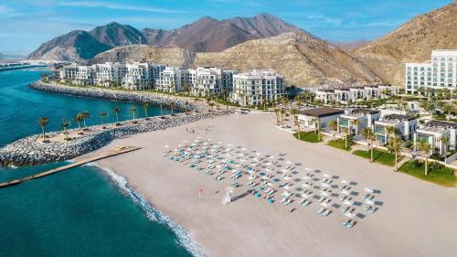 an aerial view of a beach with white umbrellas at Capital Stay- Private Two Bed Apartment - The Address Beach Resort Residences Fujairah in Fujairah