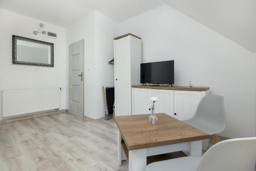 a living room with a table and a tv at Krab in Rewal