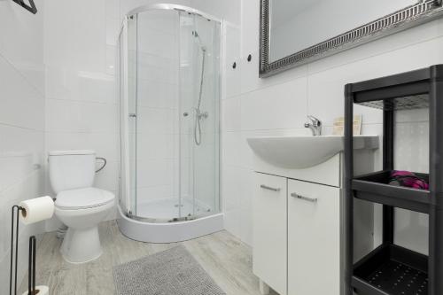 a white bathroom with a toilet and a sink at Krab in Rewal