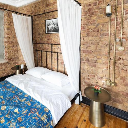 a bedroom with a bed and a brick wall at Beyoğlu'nda 4+1 ferah, manzaralı tarihi daire in Istanbul