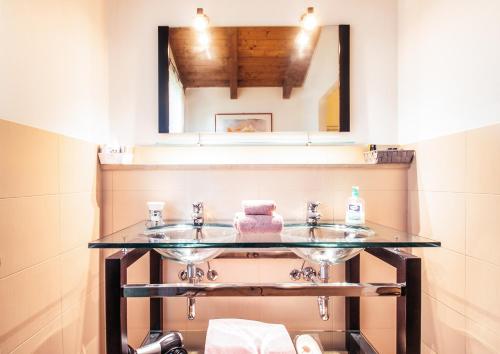 a bathroom with two sinks and a mirror at Relais Cascina San Martino in San Marzano Oliveto