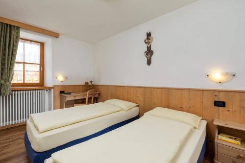 1 Schlafzimmer mit 2 Betten und einem Schreibtisch in der Unterkunft Cesa Raggio di Sole Bilocale in Livinallongo del Col di Lana
