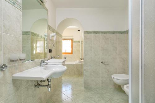 Baño blanco con lavabo y aseo en Cesa Raggio di Sole Bilocale, en Livinallongo del Col di Lana