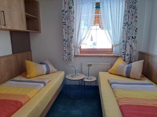 two beds in a room with a window at Appartementhaus Egger in Kaprun