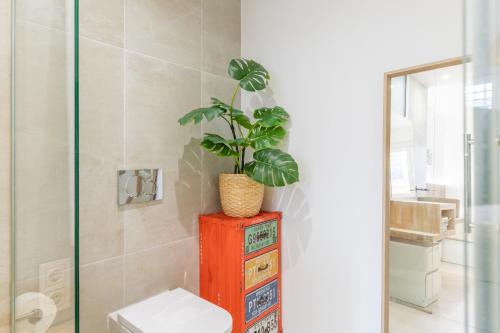 a bathroom with a toilet and a plant on a dresser at Albir Playa in L’Alfàs del Pi