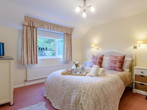 a bedroom with a bed with a tray of food on it at 4 Bed in Symonds Yat 79373 in Goodrich