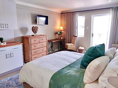 una camera da letto con un letto, un comò e una finestra di Ships Bell 17B a St Francis Bay