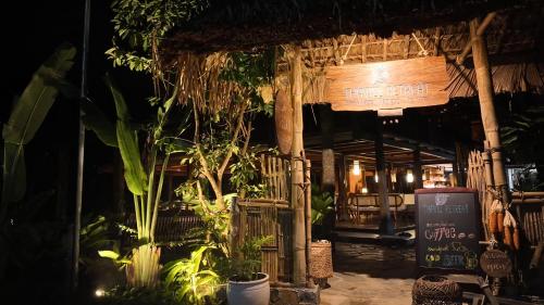 a restaurant with a sign and some plants at Thavill Retreat HaGiang in Ha Giang