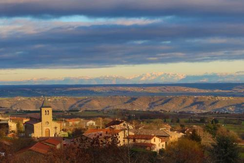 a small town with a church and mountains in the background at Château de Villars in La Chapelle-Villars