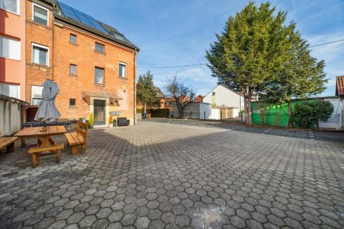 une cour vide avec des bancs et un parasol dans l'établissement Salí Homes Casablanca Cozy Apartment with Parking and Laundry Room Perfect for Your Getaway, à Bayreuth