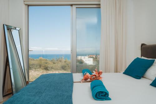 Schlafzimmer mit einem Bett und einem großen Fenster in der Unterkunft Seaside Luxury Villa in Paralimni